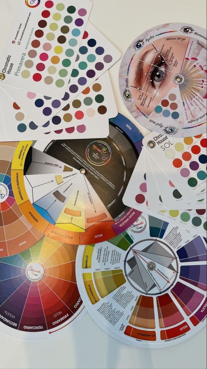 Abanicos de colorimetría y círculo cromático sobre una mesa